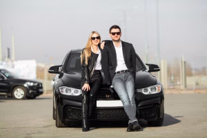 Couple posing with black car in Dubai, ideal for affordable car rentals, representing cheap and budget picks for 2025.